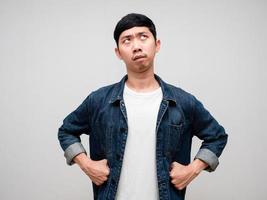 Negative asian man feels bored gesture hand at waist looking up isolated photo