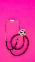 Stethoscope isolated on pink background photo