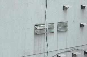 blanco al aire libre puertas con múltiple pequeño ventanas y vaso fachada, con agua fuga dañar en el paredes sencillo arquitecturas edificio con cromo lunar colores. foto