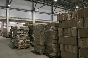 Storage warehouse with packaged goods on wooden pallet at recycle paper factory. Preparation shipment of products. Logistics, transportation and distribution facility for delivery. Supply chain cargo photo