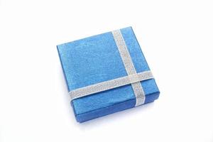Blue gift box with silver ribbon on white background. Wedding, birthday, Valentine's Day, Mother's Day, Women's Day concept. Idea for congratulation, invitation, greeting card. Flatlay, top view photo