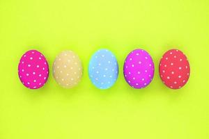Easter coloured eggs with polka dot on neon yellow background. Flatlay postcard creative concept. Isolated decorated card, poster, banner, web, magazine. Minimal idea with copy space, close up spring photo