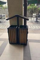 Single rubbish bin, garbage and waste bin made of wooden material. A garbage collection tank in the corner of building. A clean container for household waste.  Wooden waste boxes or trash bin. photo
