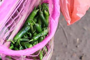 Cayenne pepper chillies pepper hanging in a sack basket from an Indonesian vegetable seller's net photo