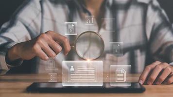 Businessman holding a magnifying glass,Audit Document Concepts, quality assessment management With a checklist, business document evaluation process, market data report analysis and consulting photo