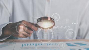 Businessman holding a magnifying glass,Audit Document Concepts, quality assessment management With a checklist, business document evaluation process, market data report analysis and consulting photo