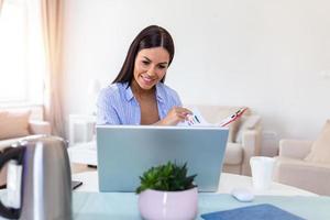 Young woman worker sit at home office reading paper document or contract feel confused with bad news, frustrated businesswoman stunned by received paperwork correspondence photo