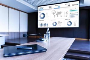 Laptop on table with presentation on projector screen in meeting room photo