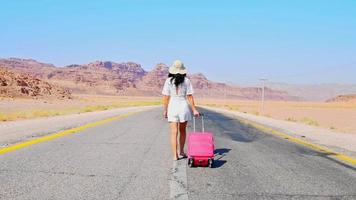 Tourist woman woman walking dragging pink luggage suitcase go travel around world of summer holiday. Lifestyles and travel concept. Travel in Jordan video