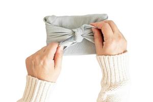 6446 Blue cloth wrapped a gift held by a woman's hands isolated on a transparent background photo