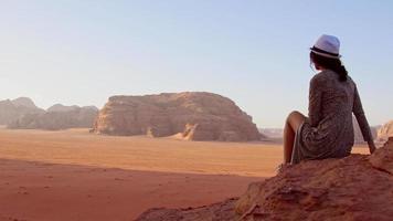 Woman tourist stand on cliff at viewpoint enjoy Wadi rum panorama on sunrise. Wadi Rum desert - valley Wadi Saabit. Jordan explore concept video