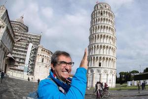 man pushing pisa leaning tower close up detail view photo