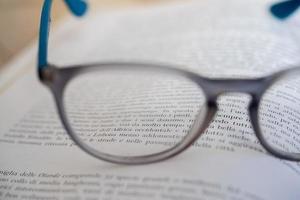 light blue reading glasses isolated on a book photo