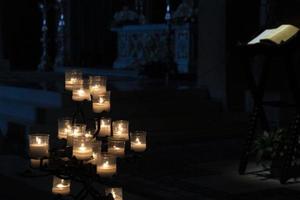 velas votivas dentro de una iglesia aislada en negro foto