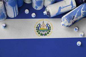 El Salvador flag and few used aerosol spray cans for graffiti painting. Street art culture concept photo