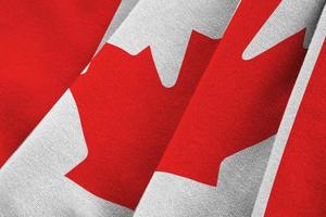 Canada flag with big folds waving close up under the studio light indoors. The official symbols and colors in banner photo