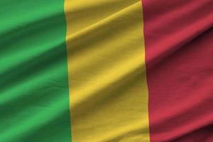 Mali flag with big folds waving close up under the studio light indoors. The official symbols and colors in banner photo