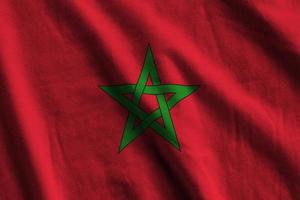 Morocco flag with big folds waving close up under the studio light indoors. The official symbols and colors in banner photo