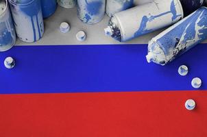 Russia flag and few used aerosol spray cans for graffiti painting. Street art culture concept photo