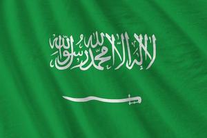 Saudi Arabia flag with big folds waving close up under the studio light indoors. The official symbols and colors in banner photo