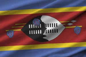 Swaziland flag with big folds waving close up under the studio light indoors. The official symbols and colors in banner photo