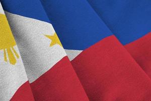 Philippines flag with big folds waving close up under the studio light indoors. The official symbols and colors in banner photo