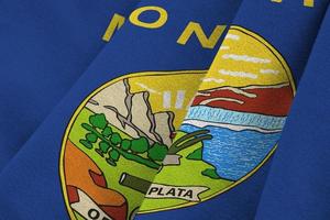 Montana US state flag with big folds waving close up under the studio light indoors. The official symbols and colors in banner photo