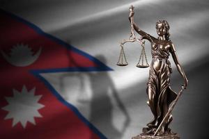 Nepal flag with statue of lady justice and judicial scales in dark room. Concept of judgement and punishment photo