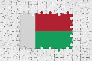 Madagascar flag in frame of white puzzle pieces with missing central part photo