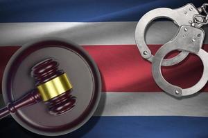 Costa Rica flag with judge mallet and handcuffs in dark room. Concept of criminal and punishment, background for judgement topics photo