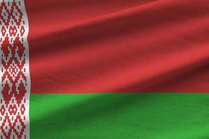 Belarus flag with big folds waving close up under the studio light indoors. The official symbols and colors in banner photo