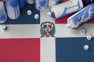 Dominican Republic flag and few used aerosol spray cans for graffiti painting. Street art culture concept photo