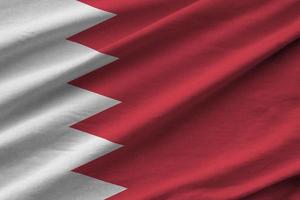 Bahrain flag with big folds waving close up under the studio light indoors. The official symbols and colors in banner photo