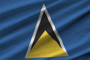 Saint Lucia flag with big folds waving close up under the studio light indoors. The official symbols and colors in banner photo