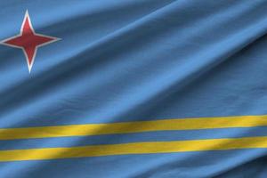 Aruba flag with big folds waving close up under the studio light indoors. The official symbols and colors in banner photo