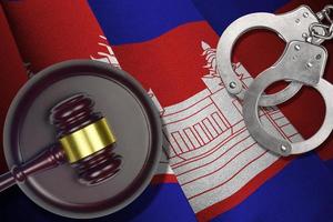 Cambodia flag with judge mallet and handcuffs in dark room. Concept of criminal and punishment, background for judgement topics photo