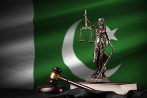 Pakistan flag with statue of lady justice, constitution and judge hammer on black drapery. Concept of judgement and guilt photo