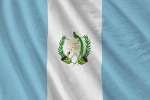 Guatemala flag with big folds waving close up under the studio light indoors. The official symbols and colors in banner photo