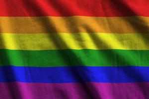 LGBT community flag with big folds waving close up under the studio light indoors. The official symbols and colors in banner photo