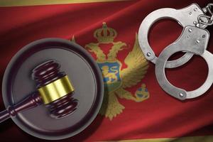 Montenegro flag with judge mallet and handcuffs in dark room. Concept of criminal and punishment, background for judgement topics photo