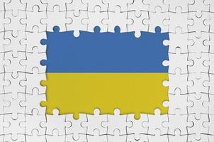 Ucrania bandera en marco de blanco rompecabezas piezas con desaparecido central parte foto