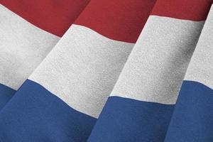 Netherlands flag with big folds waving close up under the studio light indoors. The official symbols and colors in banner photo