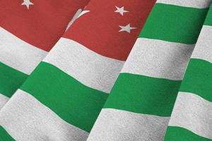 Abkhazia flag with big folds waving close up under the studio light indoors. The official symbols and colors in banner photo