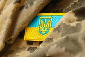 Military camouflage fabric with ukrainian flag on uniform chevron photo