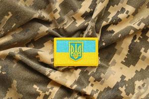 Military camouflage fabric with ukrainian flag on uniform chevron photo