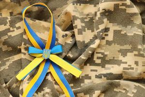 Military camouflage fabric with ukrainian stripes on ribbon photo