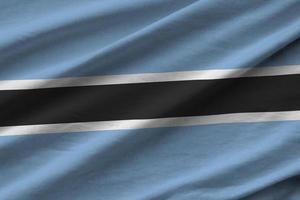 Botswana flag with big folds waving close up under the studio light indoors. The official symbols and colors in banner photo