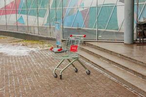 An empty cart from the supermarket in front of the entrance to the store. photo