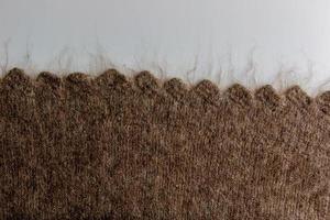 Close up on knit woolen fur texture. Melange fluffy woven thread sweater or scarf as a background. photo