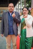 New Delhi, India - December 04 2022 - Unidentified people showing their ink-marked fingers after casting votes in front of polling booth of east Delhi area for MCD local body Elections 2022 photo